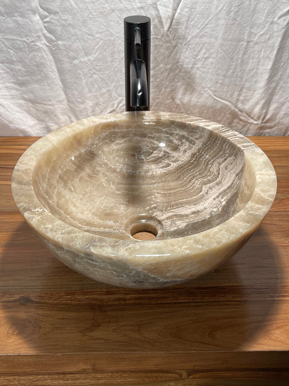 A round mixed gray onyx colored stone vessel sink with all surfaces polished at impact imports of Boise, idaho
