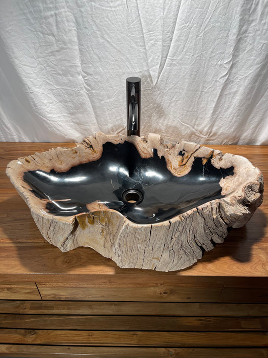 Large petrified wood vessel sink with black and brown colors and a highly polished bowl with natural exterior at Impact Imports in Boise, Idaho